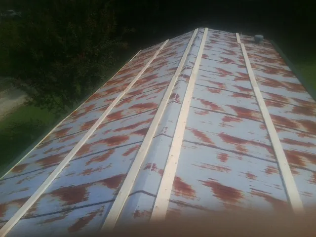 Rusted metal roof panels with new wood purlins before replacement — Storm Damage Roof Repair in Underwood by Roofing Brothers